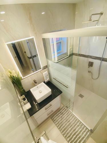 a white bathroom with a sink and a shower at Jadens Guest House - by ZenBreak in Saint Michael