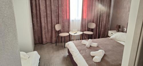a hotel room with a bed with towels on it at Vila Armonia in Curtea de Argeş