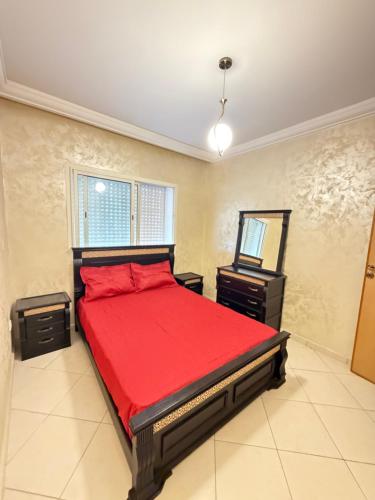 a bedroom with a bed with a red comforter at Assafa in Agadir