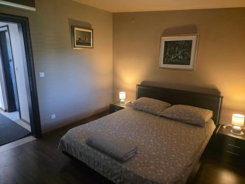 a bedroom with a bed with two lamps on it at Petra in Poreč