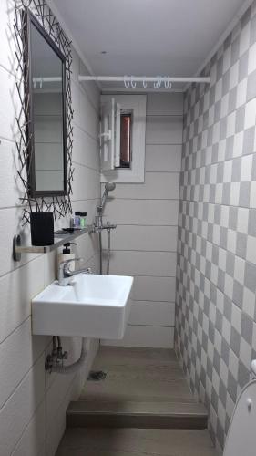a bathroom with a white sink and a mirror at The Suite in Kavála