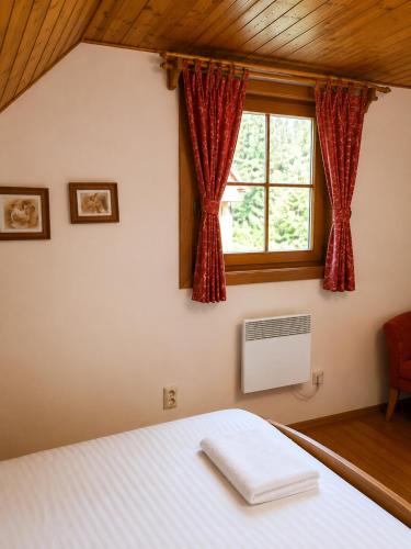 a bedroom with a bed and a window at Drevenica Podkovička - Terchová in Terchová