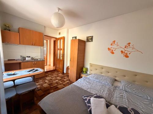 a bedroom with a bed and a small kitchen at Spokojna Zagroda in Biały Dunajec