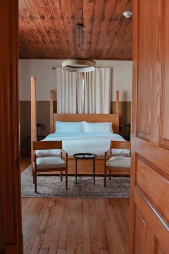 a bedroom with a bed with two chairs and a table at The Mansard House in Galveston