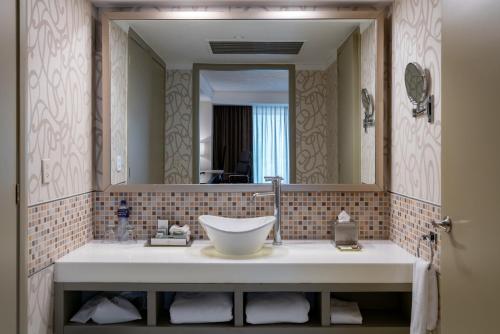 a bathroom with a sink and a large mirror at Barcelo Guadalajara in Guadalajara