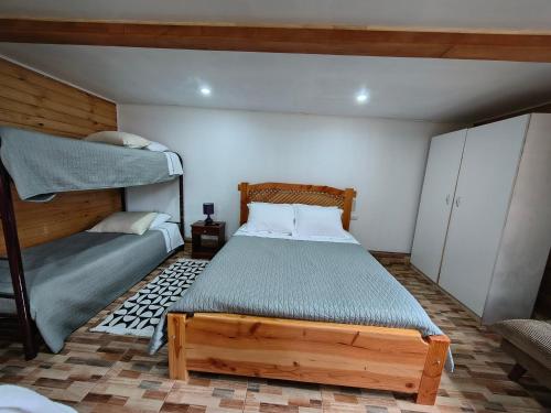 a bedroom with a bed and a bunk bed at Cabañas CyG 2 - Chaitén in Chaitén