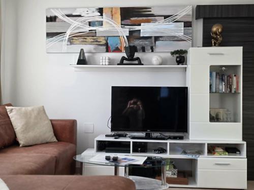 a living room with a tv on a white entertainment center at Nova Residence in Pula