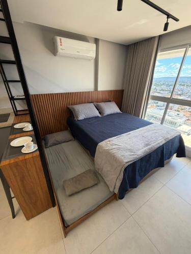 a bedroom with a bed with a ladder and a window at Flat mobiliado no CITY HOUSE in Barreiras