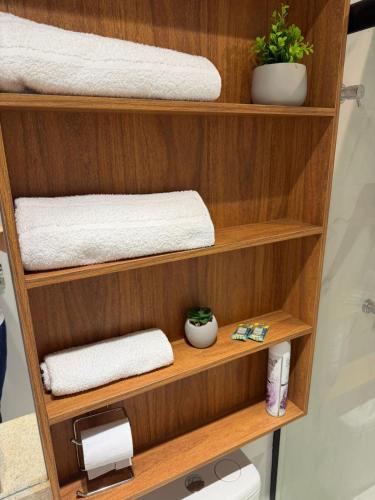 a shelf with towels and toilet paper in a bathroom at Flat mobiliado no CITY HOUSE in Barreiras
