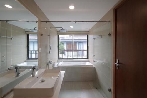 a bathroom with a tub and a sink and a mirror at Nova Villas Phu Quoc in Phú Quốc