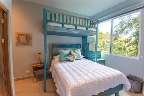 a bedroom with a blue bunk bed and a window at Villa Costa Vida Tower Suites in Quepos