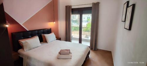 a bedroom with a bed with a black headboard and a window at theasis1 in Neos Marmaras