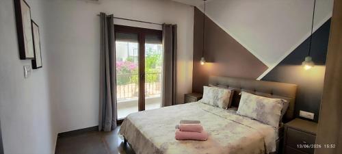 a bedroom with a bed with a pink pillow on it at Theasis 2 in Neos Marmaras