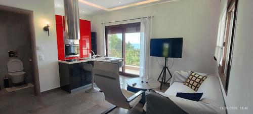a living room with a couch and a desk and a television at Theasis 2 in Neos Marmaras