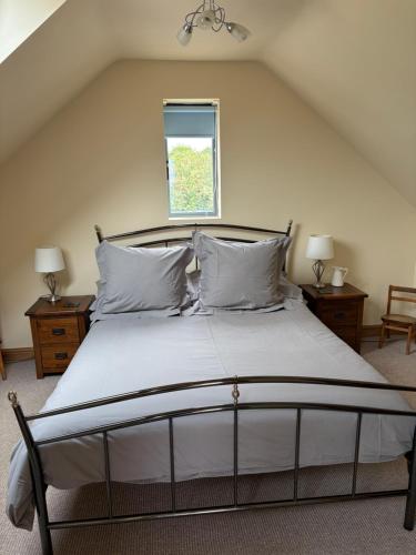 a bedroom with a large bed with white sheets and pillows at The Old School Loft in Blidworth