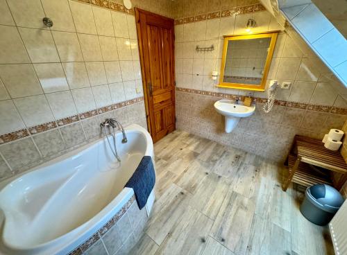 a bathroom with a tub and a sink at Penzion pod Šerákem - celý objekt Ostružná - Jeseníky in Ostružná