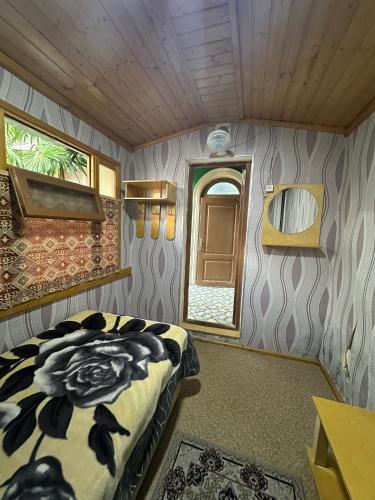 a bedroom with a bed in a room with a window at Khan House in Sheki