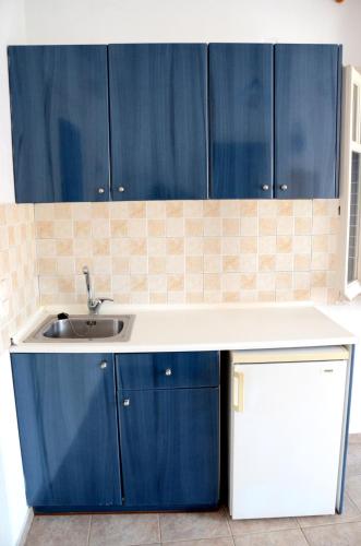 a kitchen with a sink and blue cabinets at Litsas Studios Kythnos in Kithnos