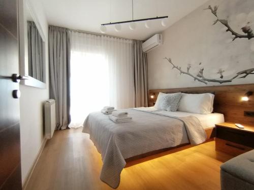 a bedroom with a bed and a large window at Apartments Knežević in Ulcinj