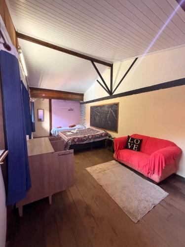 a room with a bed and a couch in it at Hotel da Vila in Nova Friburgo