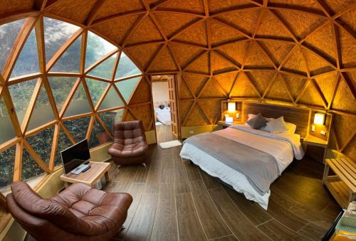 a bedroom in a yurt with a bed and chairs at Glamping Green Garden Suite in Villa de Leyva