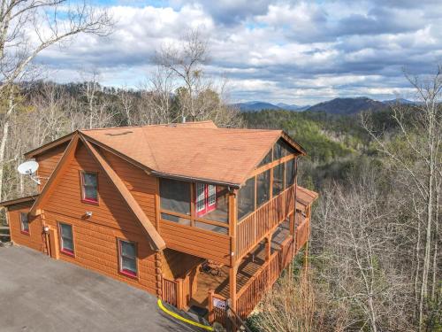 a large wooden house in the middle of a forest at Breathtaking Views No-Stair Entry, Hot Tub, Pool Table & Seasonal Pool Access in Sevierville