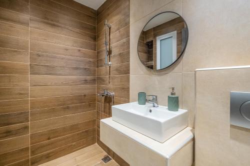 a bathroom with a white sink and a mirror at Athena's Studios 2 in Polychrono