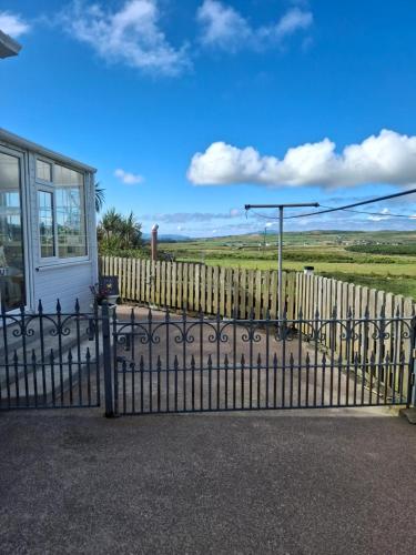 a fence in front of a house at Skellig View Harbour View Sunrise Apartment in Portmagee