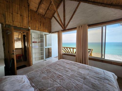 a bedroom with a bed with a view of the ocean at Casa Las Mantas Santa Marianita in Santa Marianita