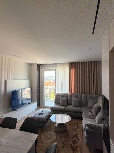 a living room with a couch and a table at Apartment 51 Luxury in Kamëz