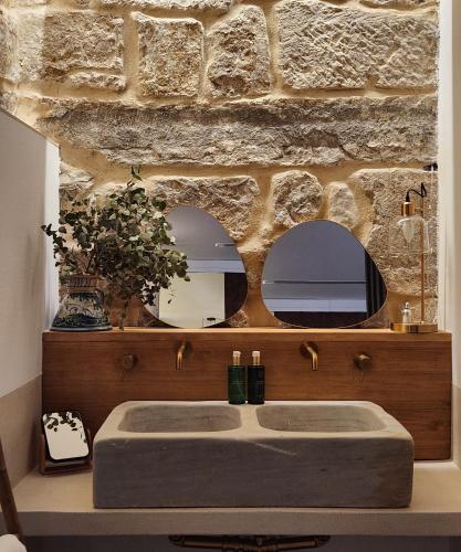 a bathroom with a sink and two mirrors at La Kasilla in Baeza