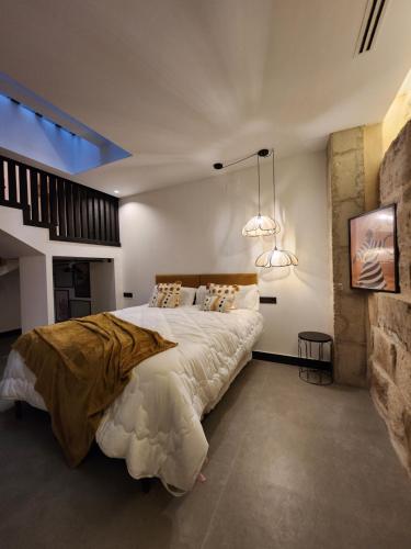 a bedroom with a large bed and two lights at La Kasilla in Baeza