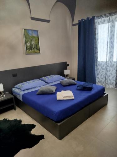 a bedroom with a large blue bed with blue sheets at Casa Muce in Novi Ligure