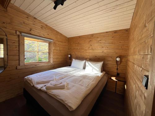 a bedroom with a bed in a wooden cabin at Jökla Guesthouse in Skjöldólfsstaðir
