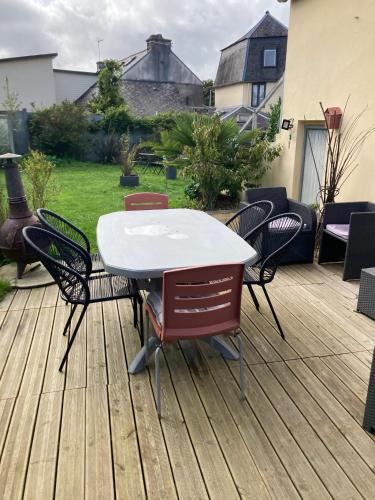 a white table and chairs on a wooden deck at chambre spacieuse indépendante PDJ inclus in Plougastel-Daoulas