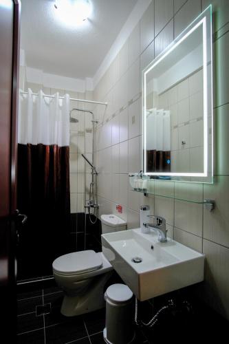 a bathroom with a sink and a toilet and a mirror at Anesis in Ioannina