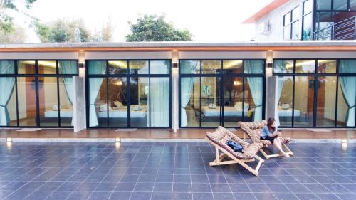 two people sitting in chairs in front of a building at Pagoda Sight Residence in Nan