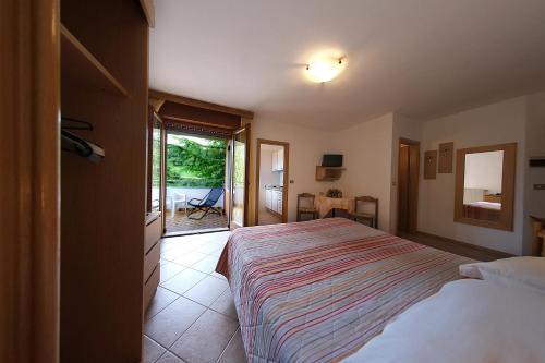 ein Schlafzimmer mit einem großen Bett und einem Balkon in der Unterkunft Hotel & Appartamenti Al Larice in Ronzone