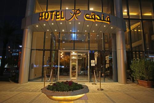 a hotel with a sign on the front of it at Qaser Alhamra Hotel Riyadh in Riyadh