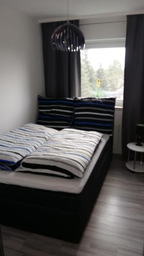 a bed in a bedroom with a window and a chandelier at Ferienwohnung Am Steinberg in Hildesheim