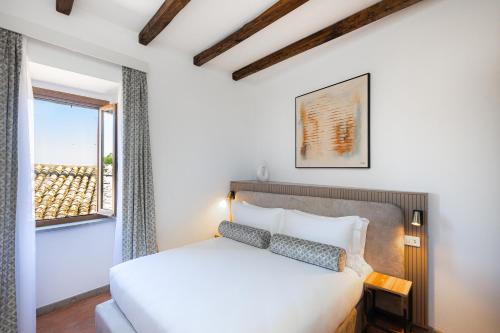 a bedroom with a white bed and a window at Marta Lake Albergo Diffuso & Spa in Marta