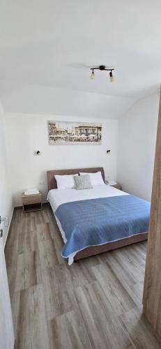 a bedroom with a large bed and a wooden floor at Apartmani Furesti 2 in Donji Stoliv