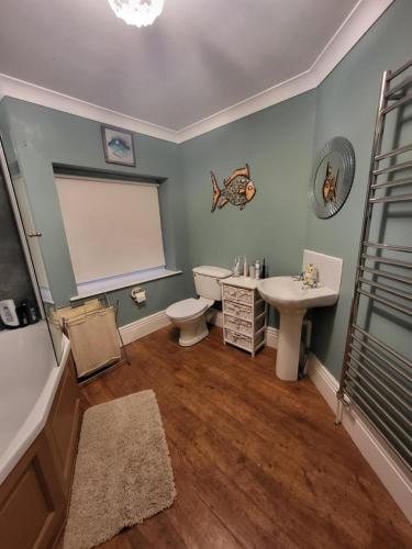 a bathroom with a toilet and a sink at Three Farthings in Cranswick