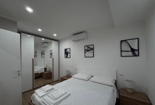 a bedroom with a white bed and a mirror at The Terry Inn in Frascati