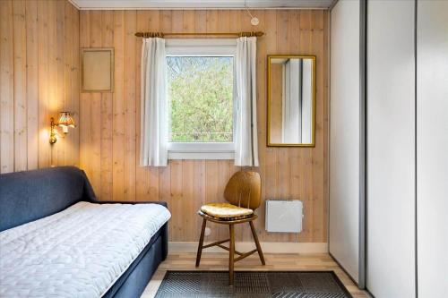 a bedroom with a bed and a window and a chair at FY140-Middelfart-Regulusvej-32 in Middelfart