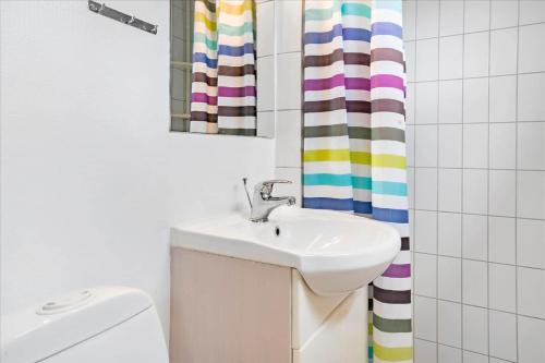 a bathroom with a sink and a shower curtain at FY140-Middelfart-Regulusvej-32 in Middelfart
