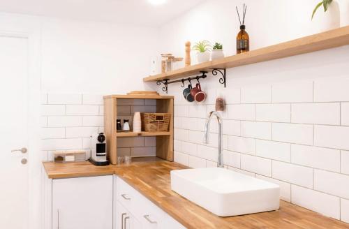 a kitchen with a sink and white subway tiles at סוויטת לה פלמורה in Eilat
