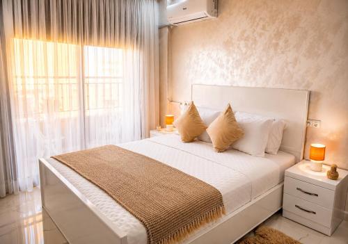 a bedroom with a large white bed with a window at Nador Skyline Al Matar in Nador