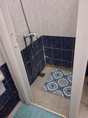 a bathroom with a shower with a blue tiled floor at Villa rafraf al hmeri in Rafrāf