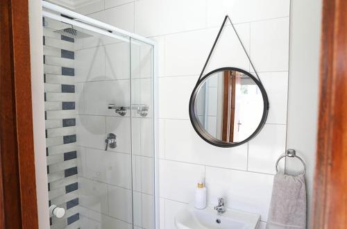 a bathroom with a mirror and a sink at Franskraal Zeehoek in Franskraalstrand